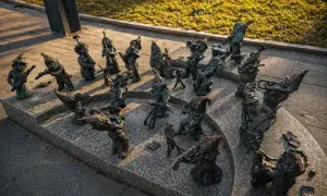 Wrocławskie krasnale, muzycy z brązu, grają na instrumentach na kamiennym postumencie.