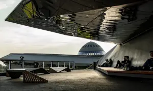 Nowoczesna architektura i nietypowe atrakcje Katowice. Ludzie odpoczywają pod futurystycznym zadaszeniem, w tle kopuła Muzeum Śląskiego.