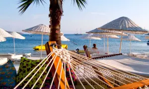 Relaks na plaży w Turcji, idealne temperatury do opalania. Hamak, palmy i błękitne morze.