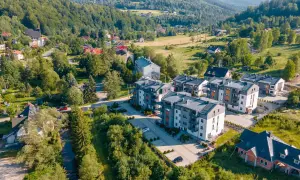 Nowoczesne apartamenty w malowniczym uzdrowisku w Beskidzie Śląskim, otoczone zielenią i górami.