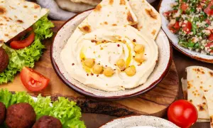 Pyszne dania kuchni libańskiej: kremowe hummus, falafel, sałatka tabbouleh i świeże pity. Idealne na wspólny posiłek.