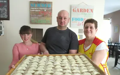 Rodzina przygotowuje pierogi. Na tacy czeka pełna micha menu, gotowa do gotowania.