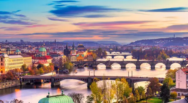 Praga o zachodzie słońca, z wieloma mostami na Wełtawie. Idealne miejsce, gdzie jechać w listopadzie, by poczuć magię miasta.