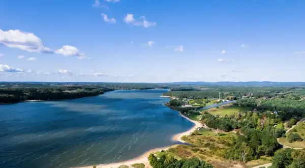 Malownicze jezioro Chańcza z piaszczystą plażą i zielonymi terenami. Idealne miejsce na wypoczynek i odkrywanie lokalnych atrakcji.