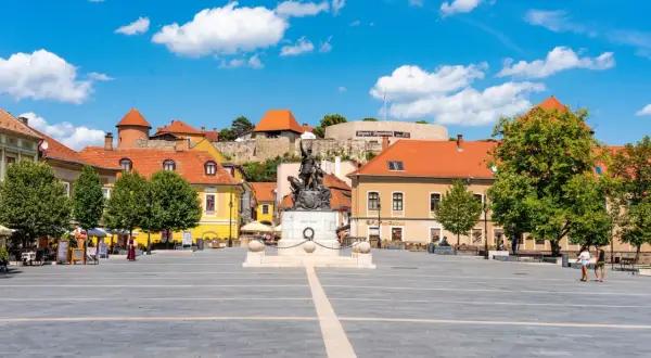 Rynek w Egerze z pomnikiem i zamkiem w tle. Wspaniałe atrakcje turystyczne i piękne widoki.