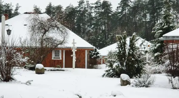 Śnieżne Boże Narodzenie na Kaszubach. Drewniane domki agroturystyki otoczone lasem i pokryte białym puchem.