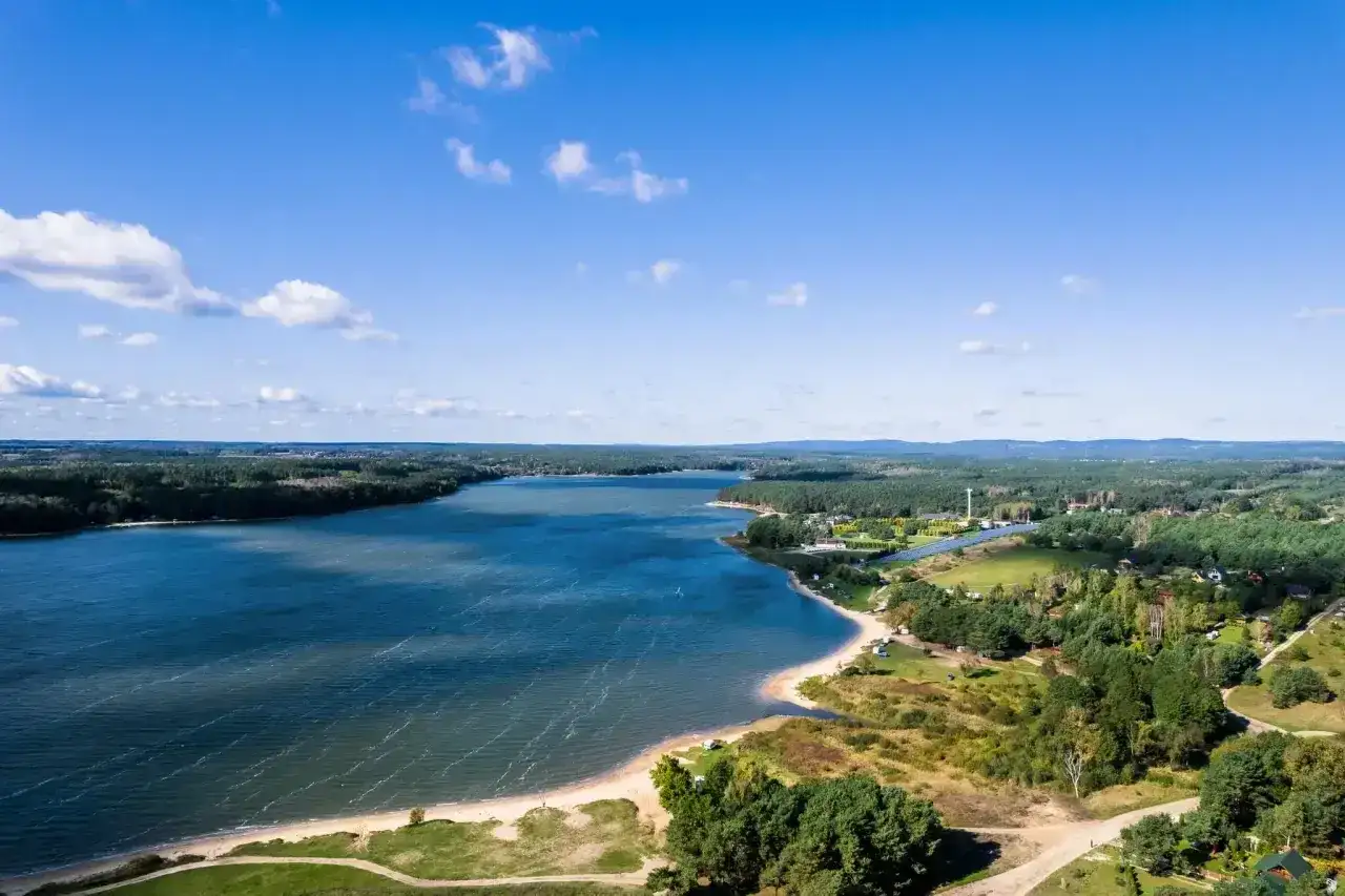 Malownicze jezioro Chańcza z piaszczystą plażą i zielonymi terenami. Idealne miejsce na wypoczynek i odkrywanie lokalnych atrakcji.