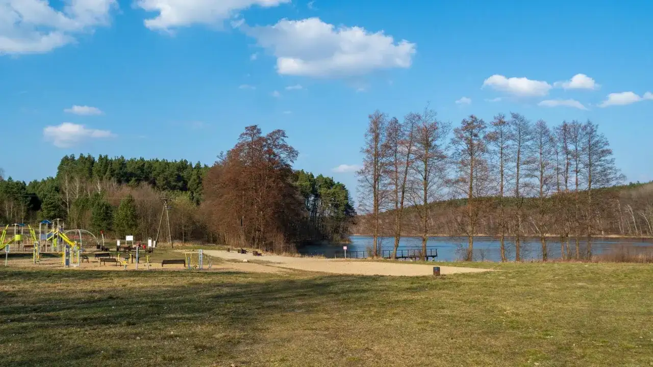 Piękny, słoneczny dzień nad jeziorem wieleńskim. Plac zabaw i siłownia na świeżym powietrzu czekają na gości.