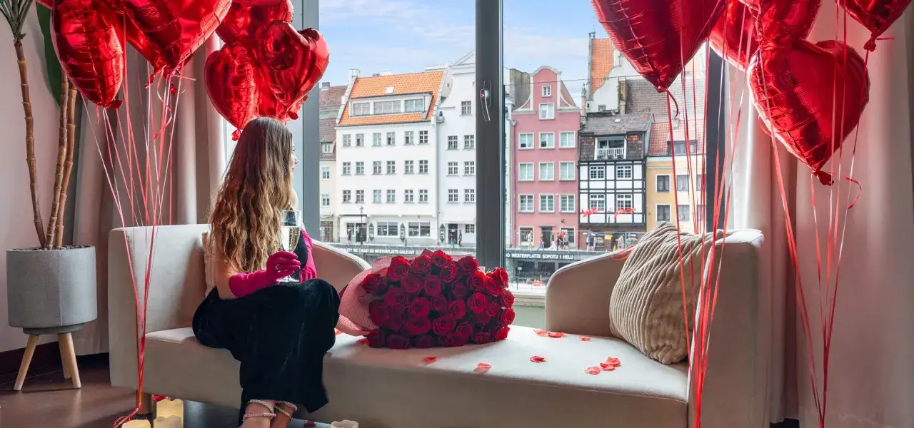 Romantyczny pokój z bukietem róż, balonami w kształcie serc i widokiem na starówkę. Idealne atrakcje dla par na wyjątkowe okazje.