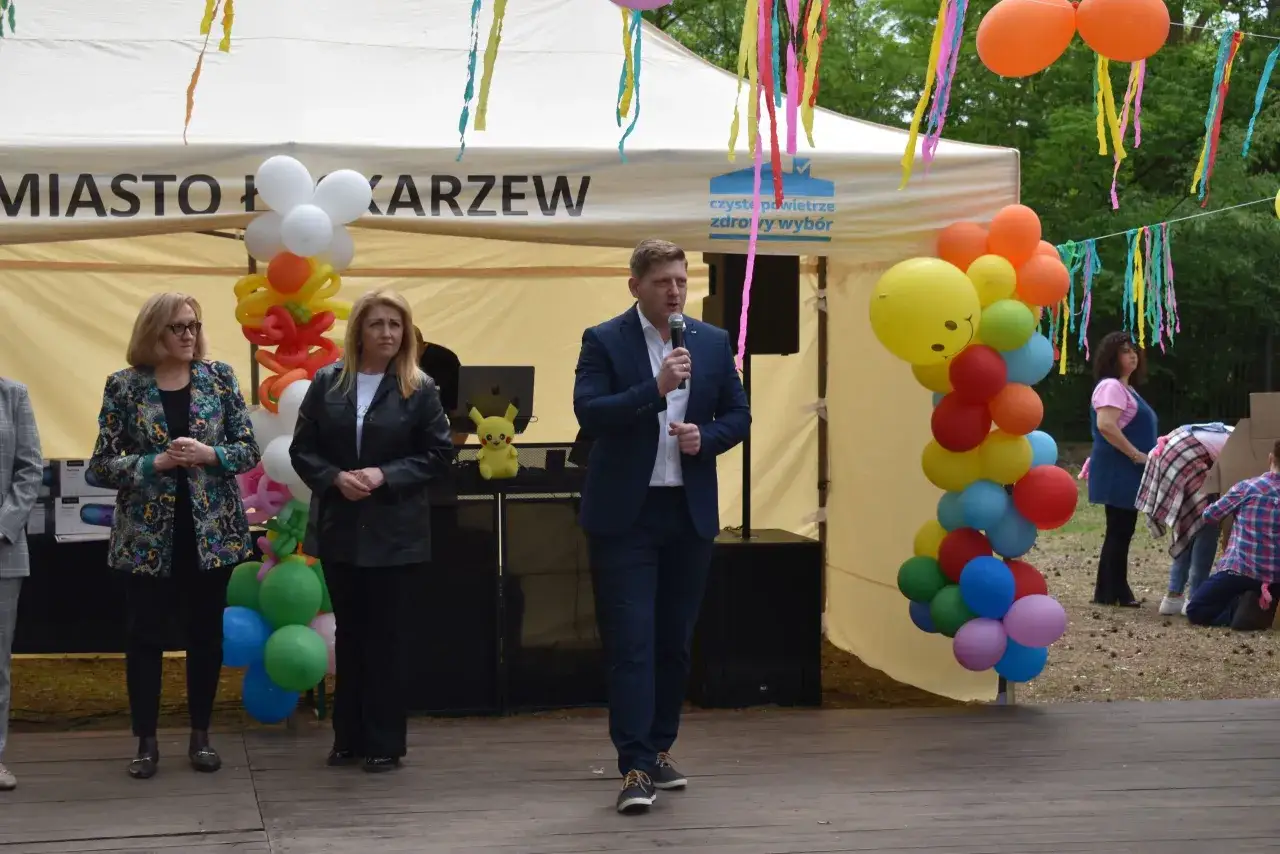 Kolorowe balony i wstążki ozdabiają namiot z napisem 