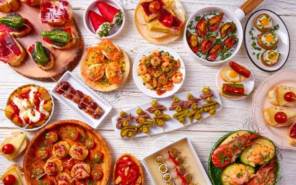Bogactwo hiszpańskiego jedzenia: tapas z krewetkami, małżami, owocami morza, wędlinami i warzywami.