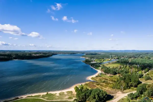 Malownicze jezioro Chańcza z piaszczystą plażą i zielonymi terenami. Idealne miejsce na wypoczynek i odkrywanie lokalnych atrakcji.