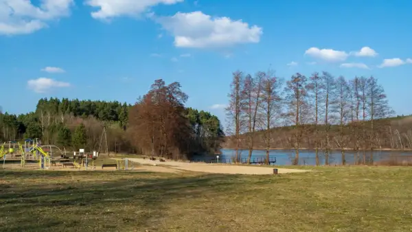 Piękny, słoneczny dzień nad jeziorem wieleńskim. Plac zabaw i siłownia na świeżym powietrzu czekają na gości.